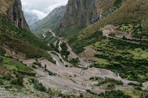 Preview: Winding mountain road is traversing through a valley with lush green vegetation