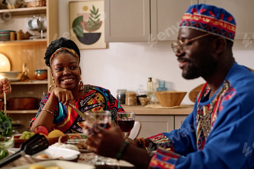 Preview: Happy African American woman in ethnic apparel looking at her husband