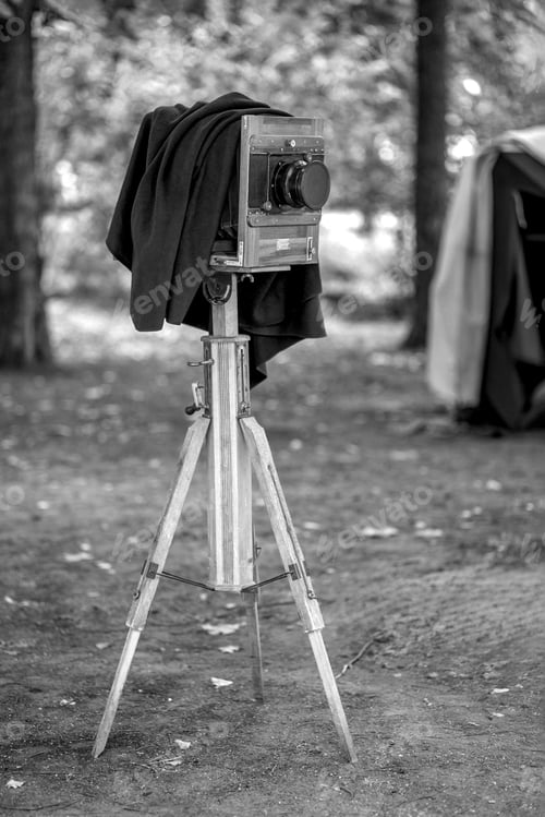 Preview: An old antique camera stands in the forest ready for shooting