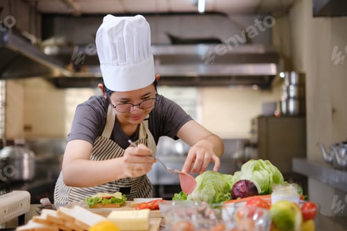 Preview: Focused chef carefully a gourmet sandwich in a professional kitchen with fresh ingredients in view