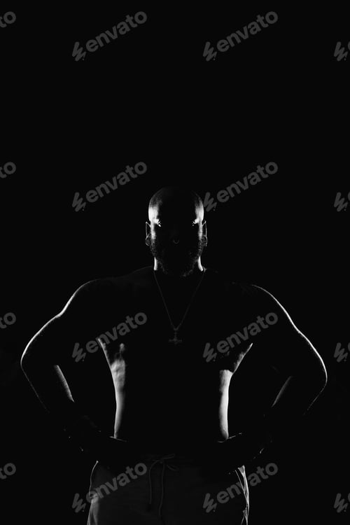 Preview: Silhouette of a muscular man with his hands on his waist in black and white in a studio shot