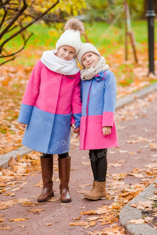Preview: Little adorable girls outdoors at warm sunny autumn day