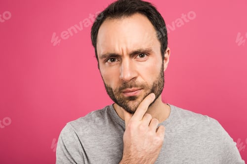 Preview: portrait of pensive man looking at camera, isolated on pink
