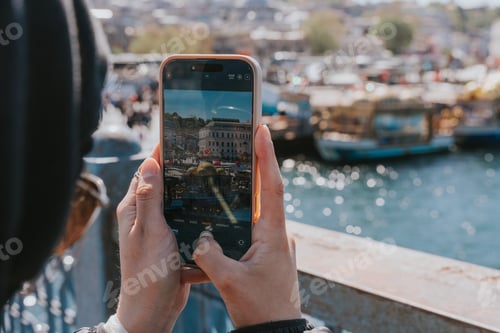 Preview: Tourist taking photo of istanbul cityscape with smartphone from galata bridge