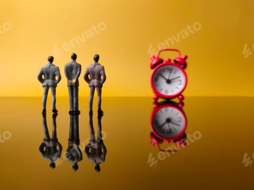Preview: Miniature people and blurry red clock with reflection
