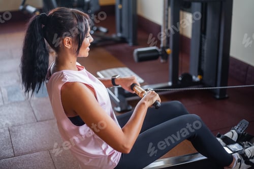 Preview: Young woman exercising with weight in the gym