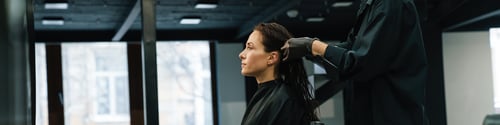 Preview: Young blonde woman dying her client's hair in beauty salon