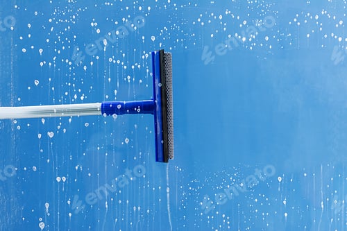 Preview: Rubber squeegee cleans window. Clears a stripe of soaped window. Cleaning service concept.