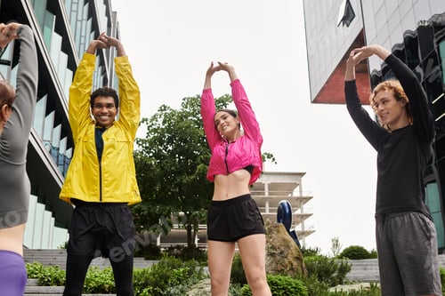 Preview: Young athletes stretch in urban setting while preparing for an energetic workout session