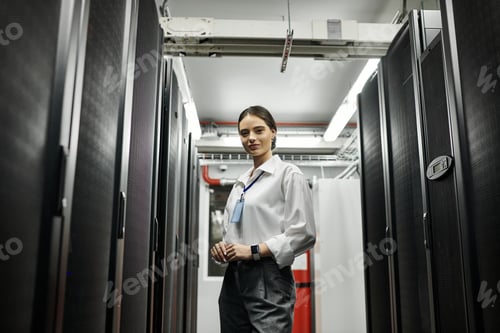 Preview: A skilled woman in a white shirt works diligently amidst advanced server hardware in a data center.