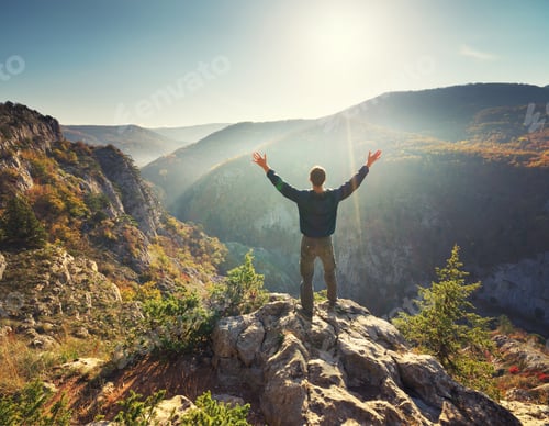 Preview: Man standing on the cliff in mountain.