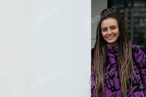Preview: Stylish informal woman with dreadlocks and piercing wears bun hairstyle