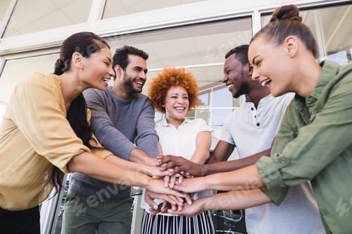 Preview: Cheerful business colleagues stacking hands