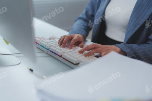 Preview: Businesswoman working at computer using keyboard in office