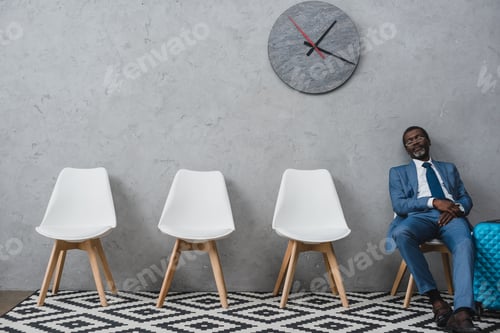 Preview: Handsome African american businessman napping in a waiting room