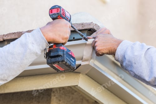 Preview: Workers Attaching Aluminum Rain Gutter to Fascia of House