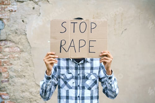 Preview: Young man holding cardboard with the inscription stop rape.