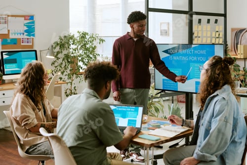 Preview: Young Adult Black Man Leading Business Presentation to Diverse Team in Office