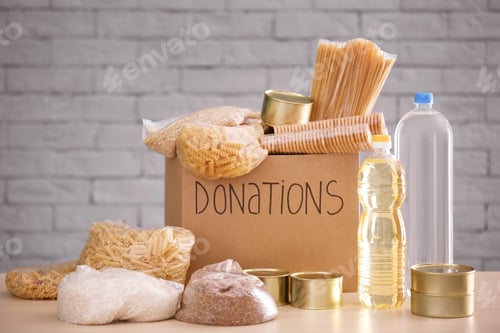 Preview: Donation box with food on table against brick wall