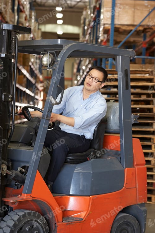 Preview: Man Driving Fork Lift Truck In Warehouse