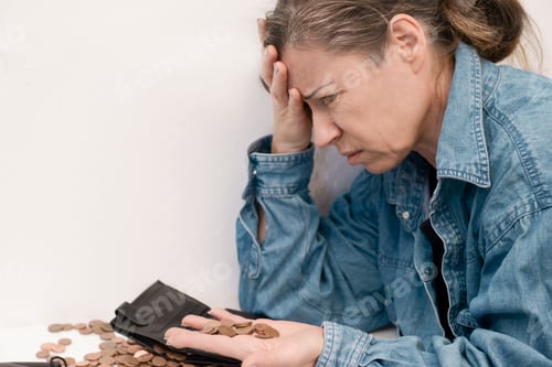 Preview: an elderly woman in old age with emotions of stress holds small euro coins in her palm
