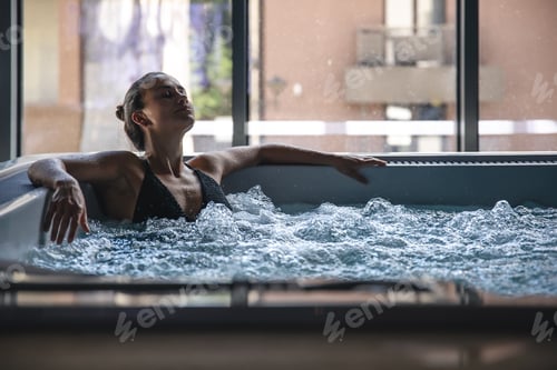 Preview: A young woman is relaxing in a jacuzzi.