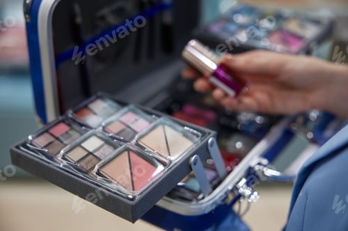 Preview: A woman is holding a lipstick very carefully in front of a makeup case