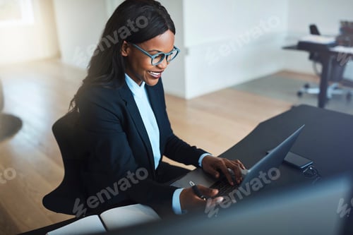 Preview: Smiling African American businesswoman working online at her office desk