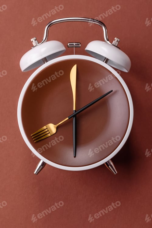 Preview: Empty plate with devices in the form of clock hands as a conceptual background for lunch time