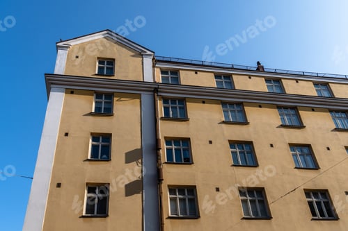 Preview: A classic yellow building against a blue sky, a glimpse of Helsinki's architecture.
