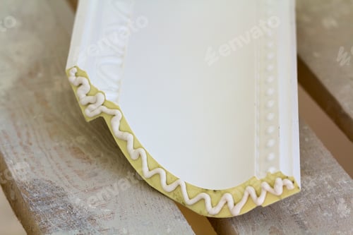 Preview: Close-up detail of decoration molding with glue adhesive before installation in interior renovation.