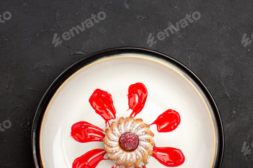 Preview: top view delicious little cake with red icing inside plate on dark desk sweet biscuit sugar pie