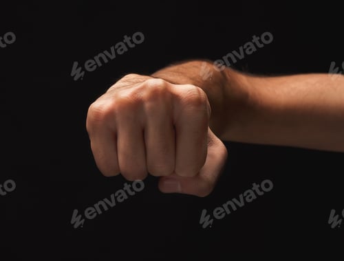 Preview: Male Hand Clenched Fist On Black Isolated Background, Low Key, Cutout. Strenght And Agression