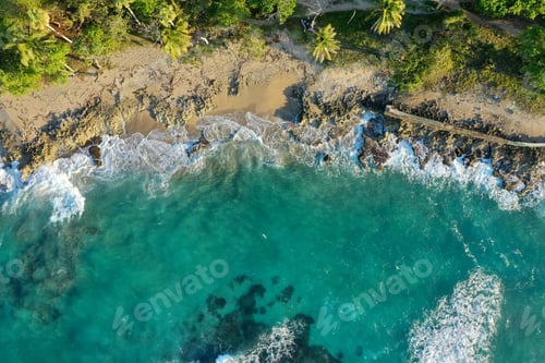 Preview: Aerial shot of cliffs covered in greenery surrounded by the sea under the sunlight