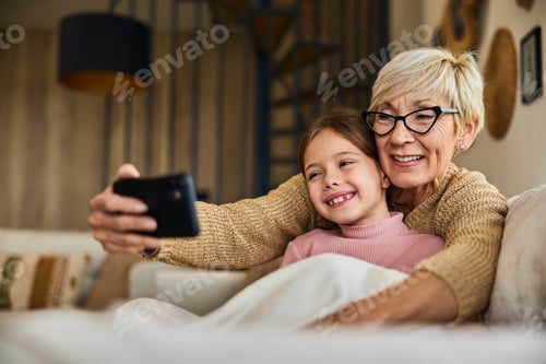 Preview: Grandmother and Granddaughter Taking Selfie Indoors