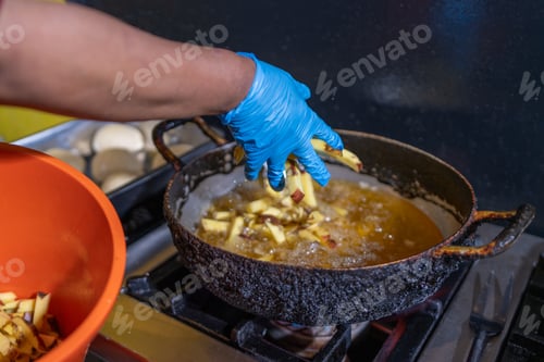 Preview: Cook adding potatoes to bubbling oil, frying french fries