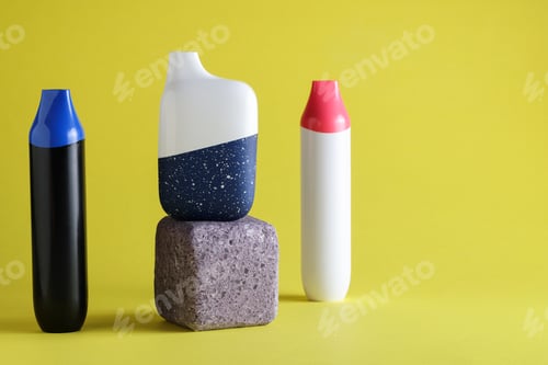 Preview: disposable electronic cigarettes or vapes on yellow background. copy space. nicotine vapor stick.