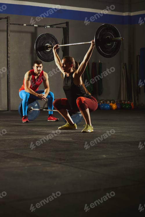 Preview: Woman squatting and lifting a barbell.