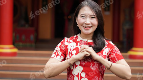 Preview: Asian Chinese woman in a cheongsam dress with congratulations gest at vihara