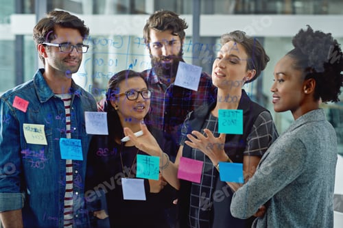 Preview: Shot of a group creative businesspeople working on a glass wall in the office