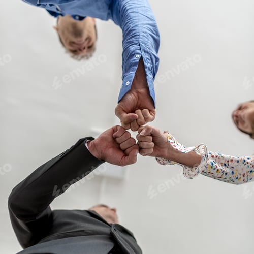 Preview: Three business people bumping their fists together