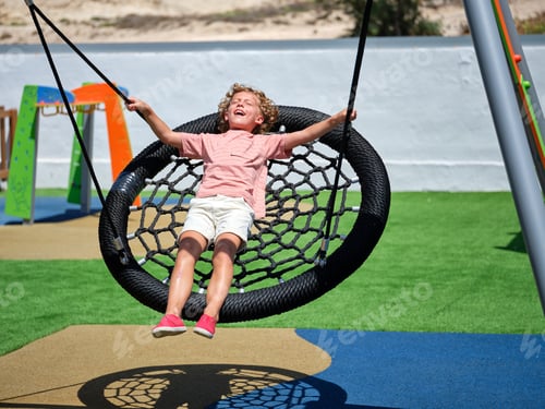 Preview: Curly shining preteen boy playing on nest swing