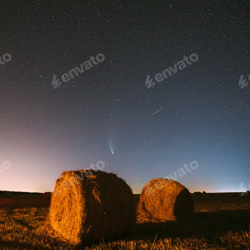 Preview: Meteor And Comet Neowise C2020 F3 In Night Starry Sky Above Haystacks In Summer Agricultural Field