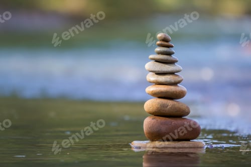 Preview: Close-up abstract image of wet rough natural brown uneven different sizes and forms stones balanced