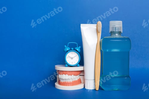 Preview: Mouthwash and other oral hygiene products on colored table top view with copy space