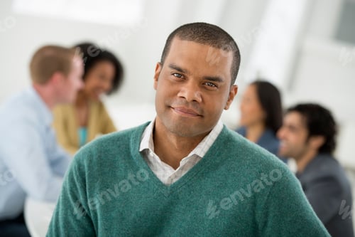 Visualização: Pessoas de negócios sentadas ao redor de uma mesa. Um homem em primeiro plano.