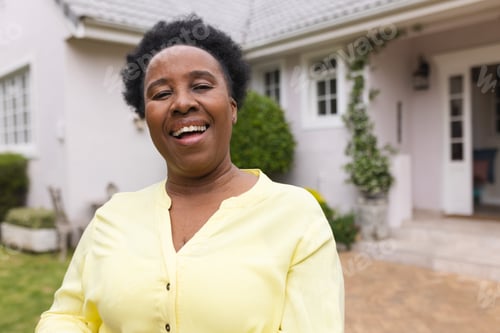 Preview: Portrait of happy senior african american woman wearing yellow shirt in garden at home