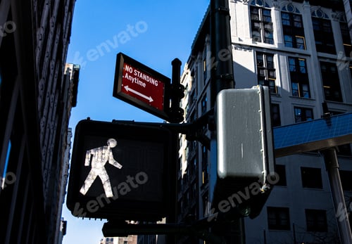 Preview: Low angle view of a walker icon under a sign text NO STANDING ANYMORE with urban buildings