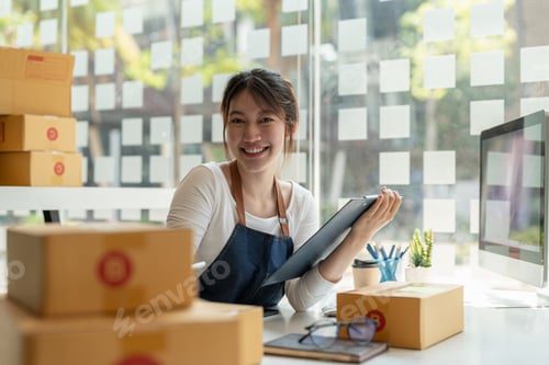Preview: Portrait of Asian young woman SME working with a box at home the workplace.start-up small business