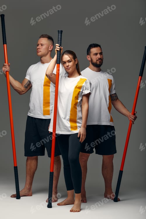 Preview: People stand together and practice sticks. Karate masters posing with sticks in the studio together.